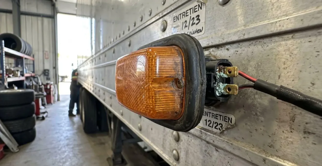 Gros plan macro sur feu clignotant latéral remorque camion montrant connecteur et détails réalistes